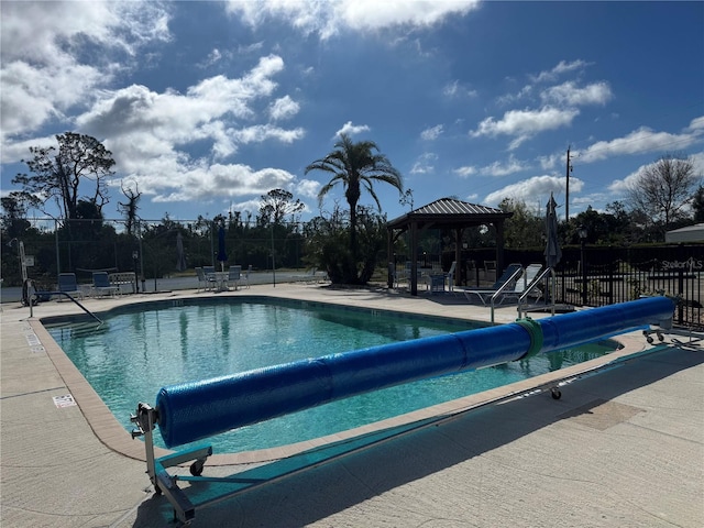 community pool with fence, a patio, and a gazebo