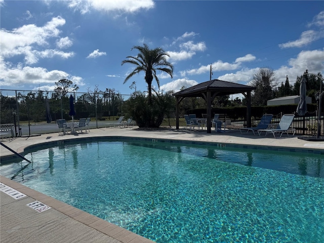 pool with fence, a gazebo, and a patio