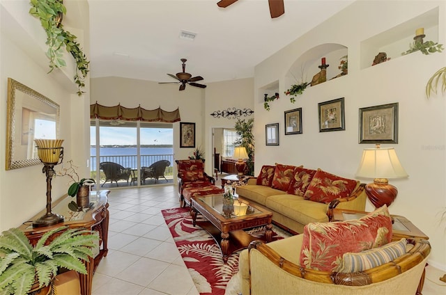 living room featuring light tile patterned floors, visible vents, and a ceiling fan