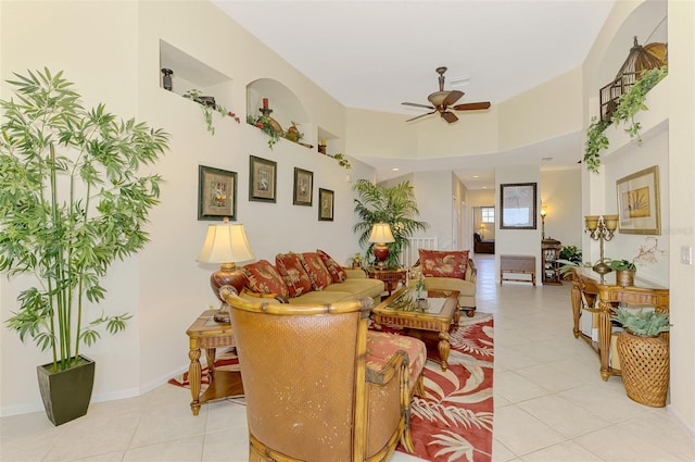 living area featuring ceiling fan, baseboards, and light tile patterned flooring