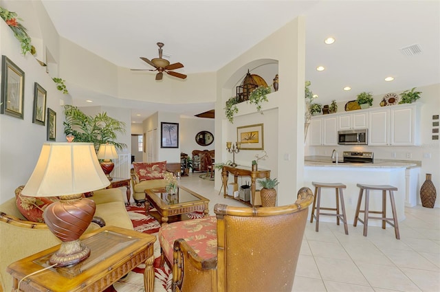 living room with light tile patterned floors, visible vents, a ceiling fan, and recessed lighting