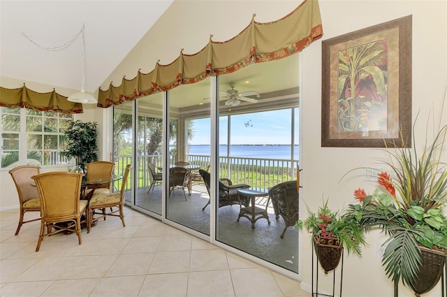 sunroom / solarium with lofted ceiling, a water view, and ceiling fan