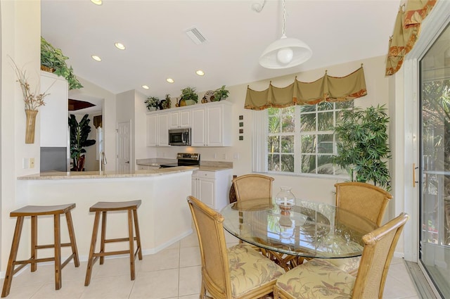 dining area with light tile patterned floors, visible vents, vaulted ceiling, and recessed lighting