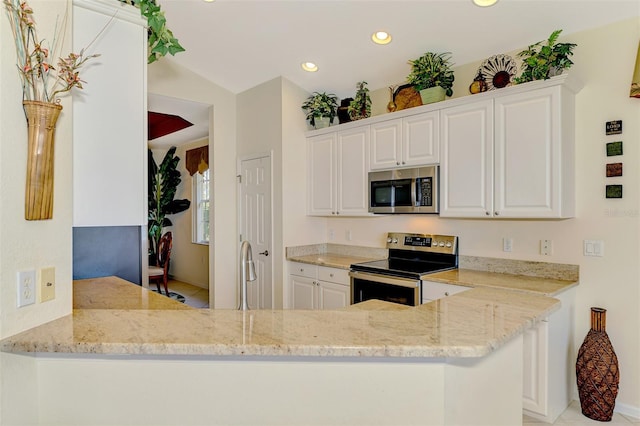 kitchen featuring stainless steel appliances, recessed lighting, white cabinets, a sink, and a peninsula