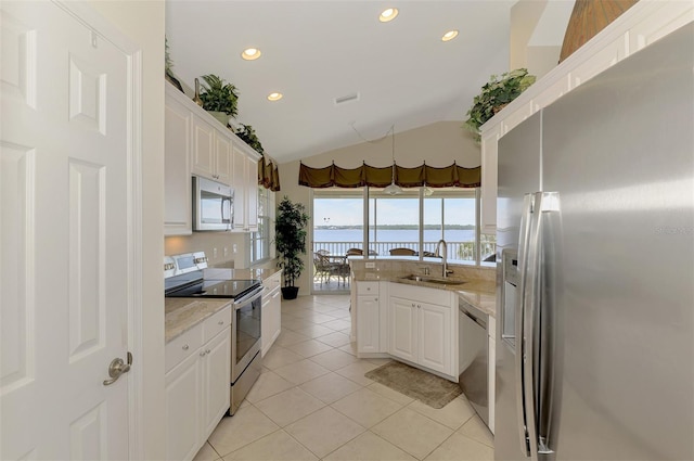 kitchen with light tile patterned flooring, a water view, a sink, white cabinetry, and appliances with stainless steel finishes