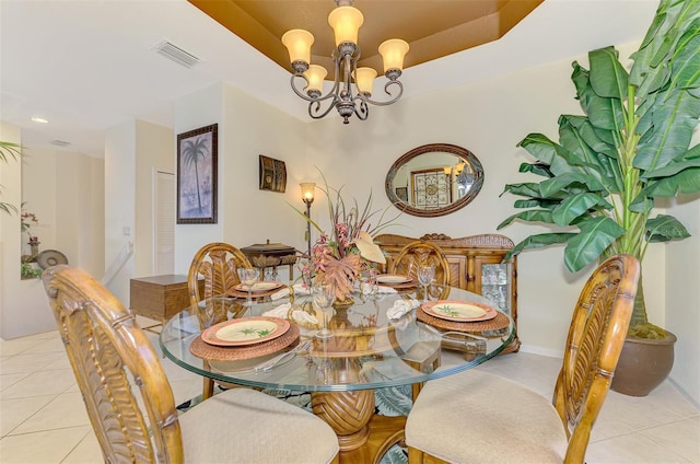 dining area with a chandelier, a tray ceiling, visible vents, and light tile patterned flooring