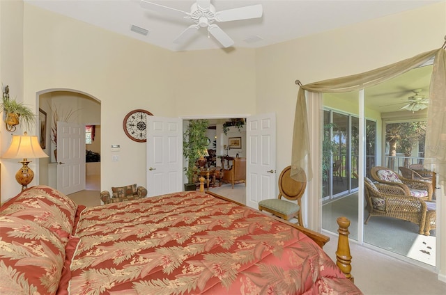 bedroom featuring arched walkways, ceiling fan, a towering ceiling, visible vents, and access to exterior