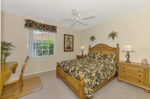 bedroom with light carpet, ceiling fan, and baseboards