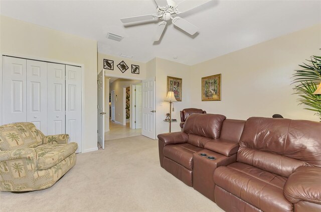 living room with a ceiling fan, light colored carpet, visible vents, and baseboards