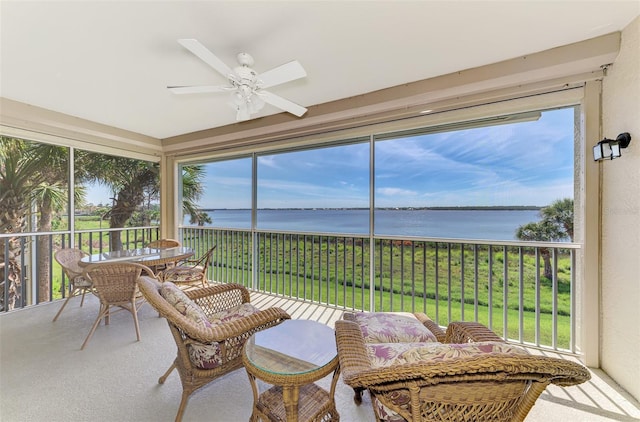 sunroom with a water view and a ceiling fan