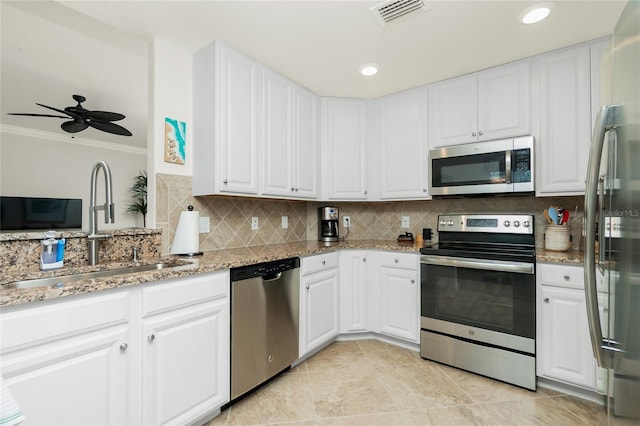 kitchen with stainless steel appliances, white cabinets, a sink, and visible vents