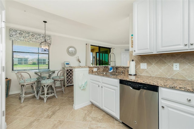 kitchen with light stone counters, decorative light fixtures, stainless steel dishwasher, white cabinets, and a sink