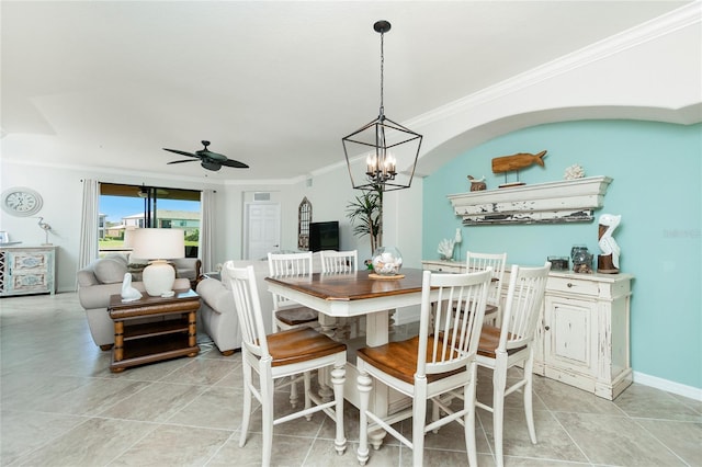 dining space featuring ceiling fan with notable chandelier, baseboards, and crown molding