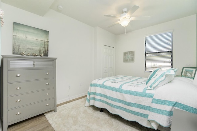 bedroom featuring light wood-style floors, a closet, ceiling fan, and baseboards