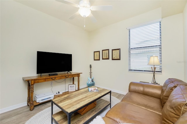 living room with baseboards, ceiling fan, and light wood finished floors