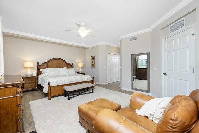 bedroom featuring ornamental molding, wood finished floors, and visible vents