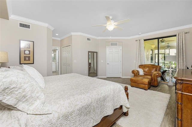 bedroom featuring light wood finished floors, visible vents, and crown molding