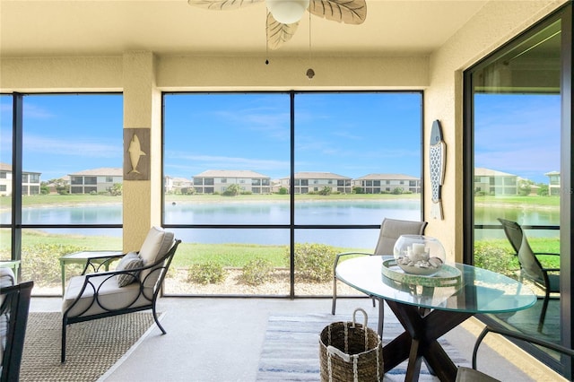 sunroom / solarium with a wealth of natural light, a water view, and a residential view