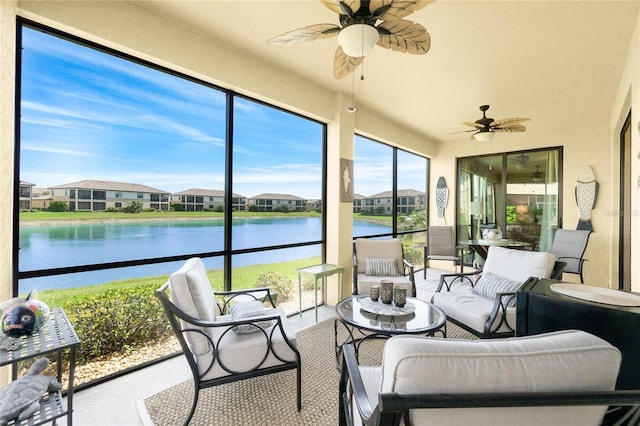 sunroom featuring ceiling fan, a water view, and a residential view