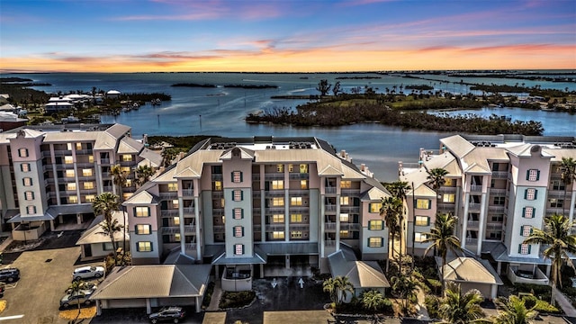 aerial view at dusk featuring a water view