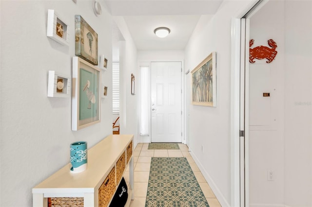 doorway featuring baseboards and light tile patterned floors