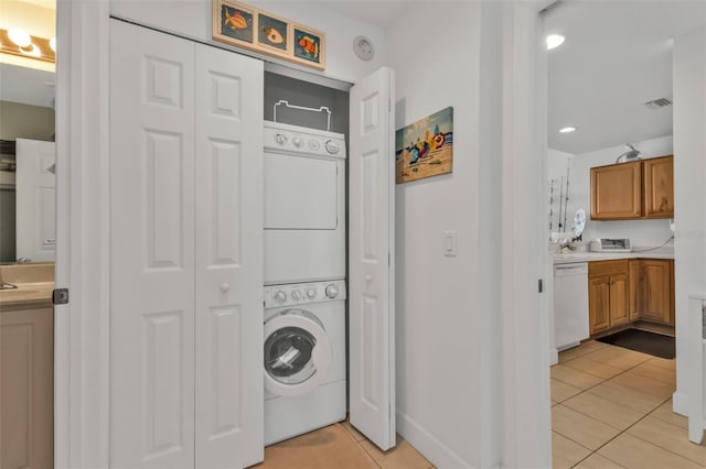 laundry room featuring laundry area, light tile patterned floors, visible vents, and stacked washer and dryer