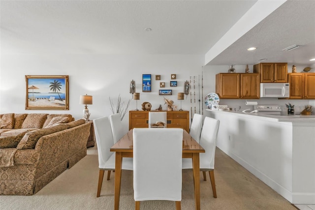 dining area with recessed lighting, visible vents, light carpet, and a textured ceiling