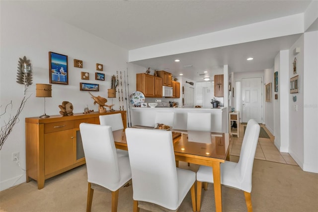 dining room with light carpet, baseboards, light tile patterned flooring, and recessed lighting