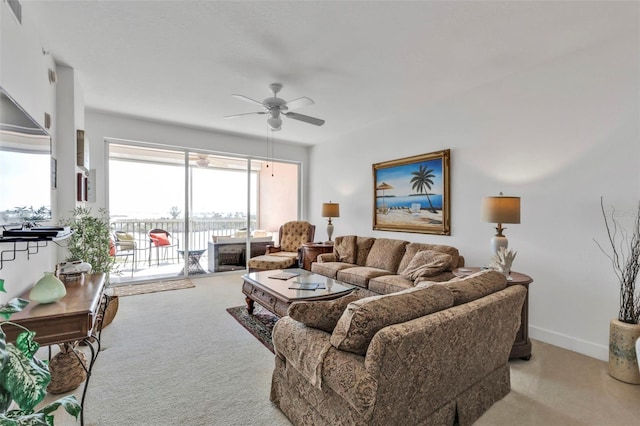 living room with ceiling fan, visible vents, baseboards, and light colored carpet