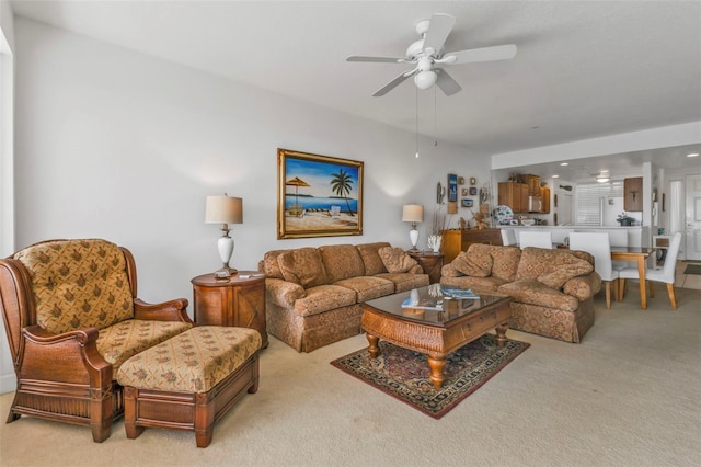 living area featuring light carpet and ceiling fan