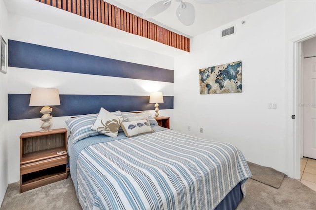 bedroom featuring a ceiling fan, visible vents, and light carpet