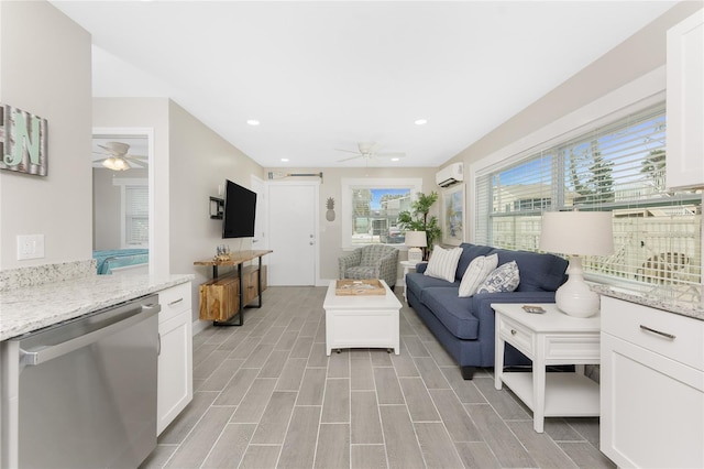 living area featuring wood finish floors, an AC wall unit, ceiling fan, and recessed lighting