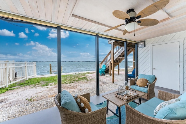 sunroom / solarium featuring wood ceiling, a water view, and a ceiling fan