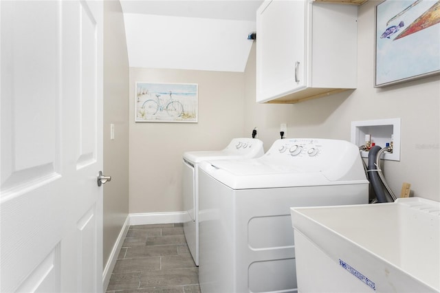 clothes washing area featuring cabinet space, baseboards, washing machine and clothes dryer, wood finish floors, and a sink