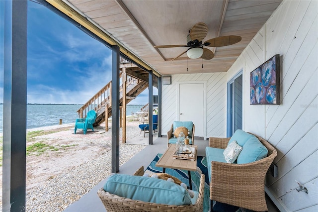 view of patio featuring a water view, stairway, and a ceiling fan