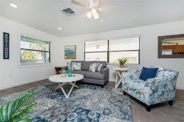 living room with recessed lighting, visible vents, baseboards, and wood finished floors