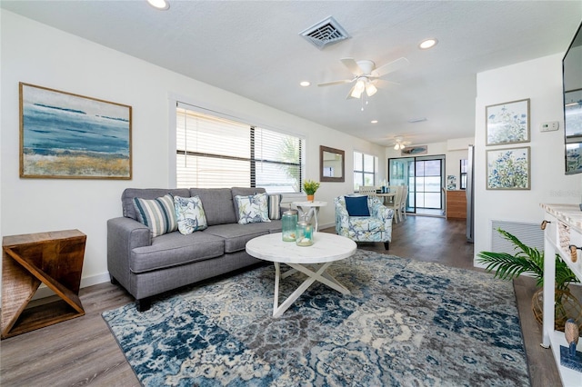 living room featuring ceiling fan, recessed lighting, wood finished floors, visible vents, and baseboards