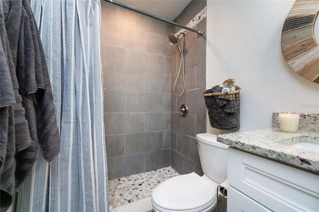 full bathroom with a stall shower, vanity, and toilet