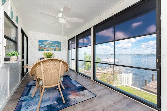 sunroom featuring a water view and ceiling fan