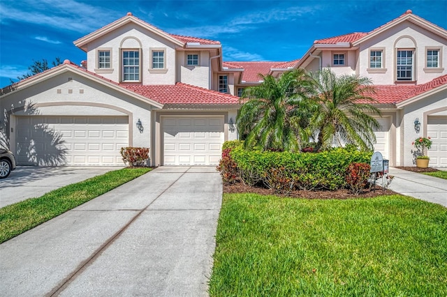 mediterranean / spanish house with a tile roof, concrete driveway, and stucco siding