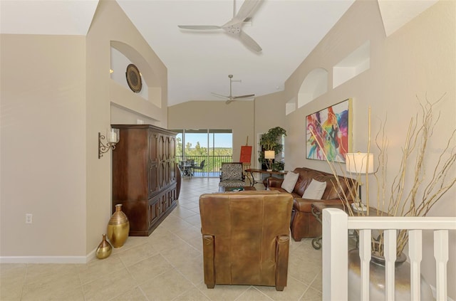 living room with ceiling fan, light tile patterned floors, vaulted ceiling, and baseboards