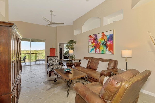 living area featuring a ceiling fan, a towering ceiling, and light tile patterned floors