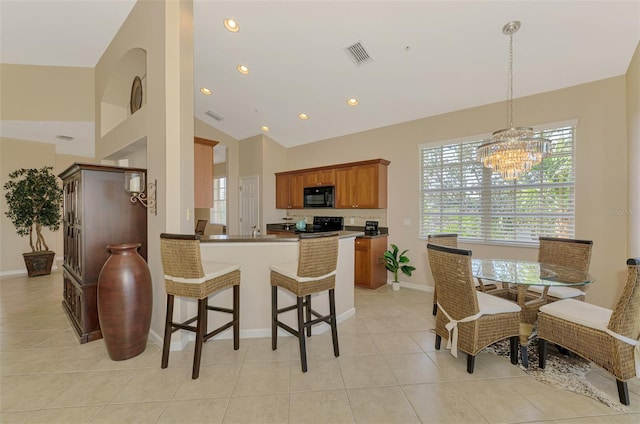 kitchen with brown cabinets, light tile patterned floors, visible vents, a peninsula, and black appliances