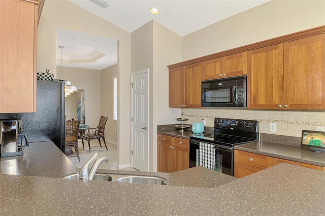 kitchen with black appliances, brown cabinets, and a sink