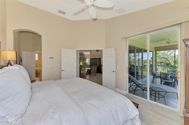 bedroom featuring visible vents, arched walkways, ceiling fan, access to exterior, and light wood-style floors