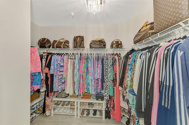 spacious closet featuring an inviting chandelier