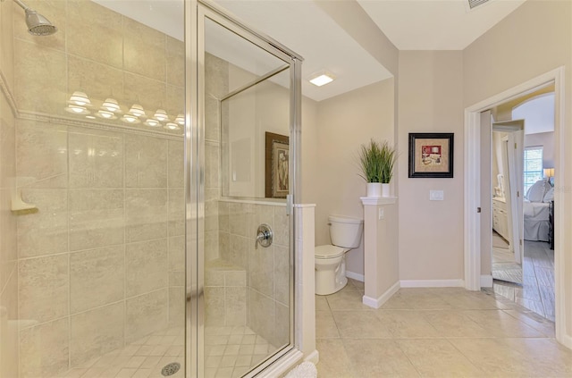 ensuite bathroom with baseboards, toilet, ensuite bath, tile patterned flooring, and a shower stall