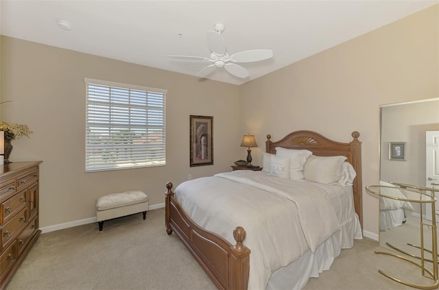 bedroom with light carpet, ceiling fan, and baseboards