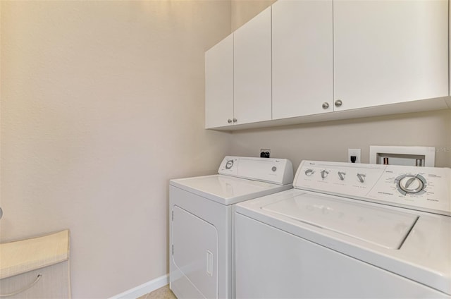 laundry area with baseboards, cabinet space, and washer and dryer