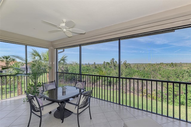 unfurnished sunroom with plenty of natural light, a view of trees, and ceiling fan